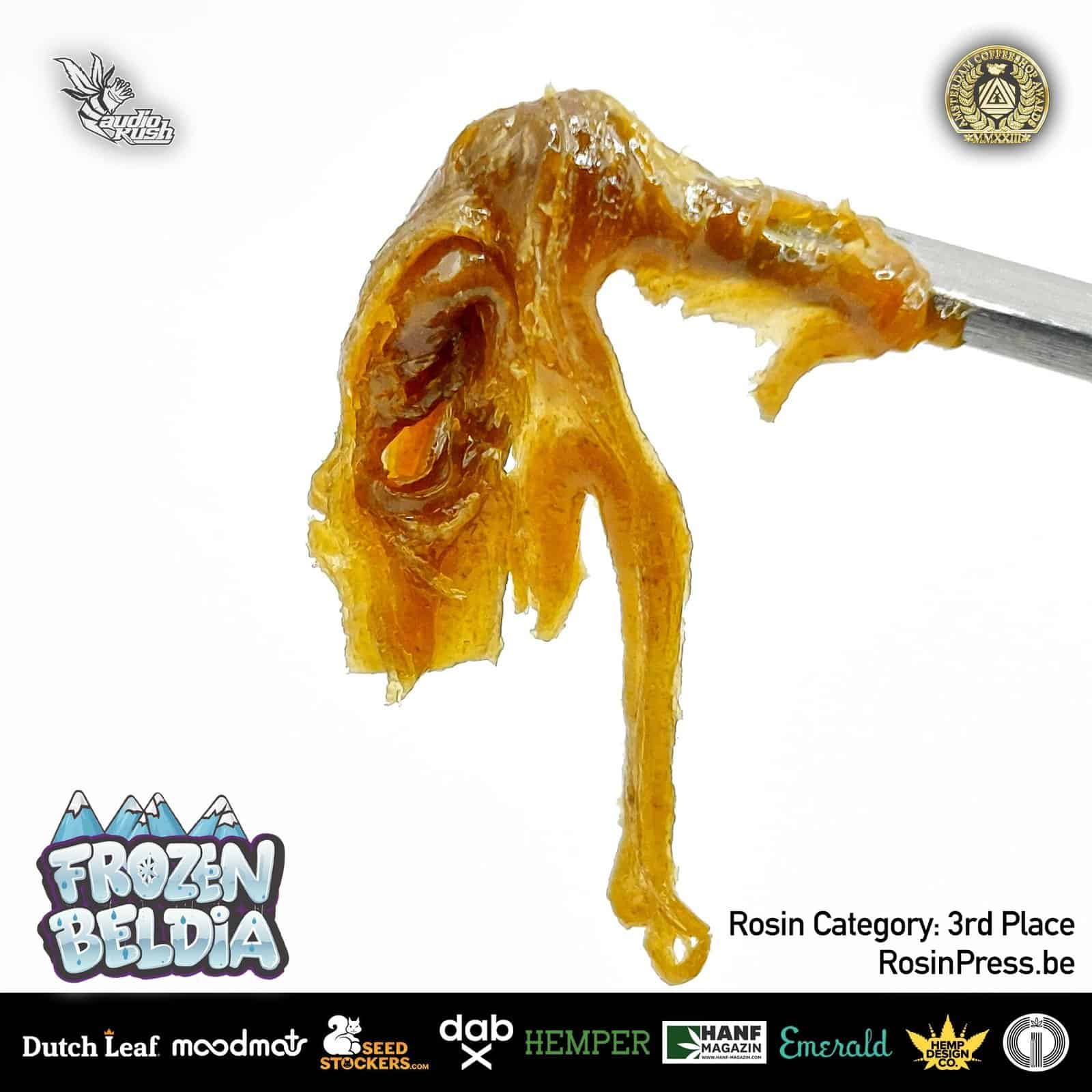 AudioKush cannabis extract close-up, rosin concentrate with amber color and textured appearance, used for dabbing and vaping, showcasing high-quality resin product.