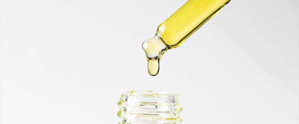 Vape e-liquid dropper over glass jar, liquid vaping flavor, e-juice for electronic cigarettes, flavoring for vape devices, CBD or cannabis oil concentrate, vaping accessories.