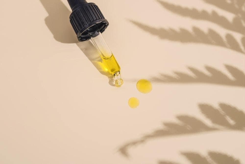 a dropper bottle filled with yellow liquid sitting on top of a table
