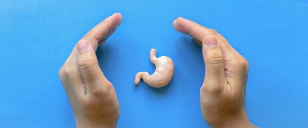 Tiny human embryo model on blue background for prenatal health and pregnancy education.