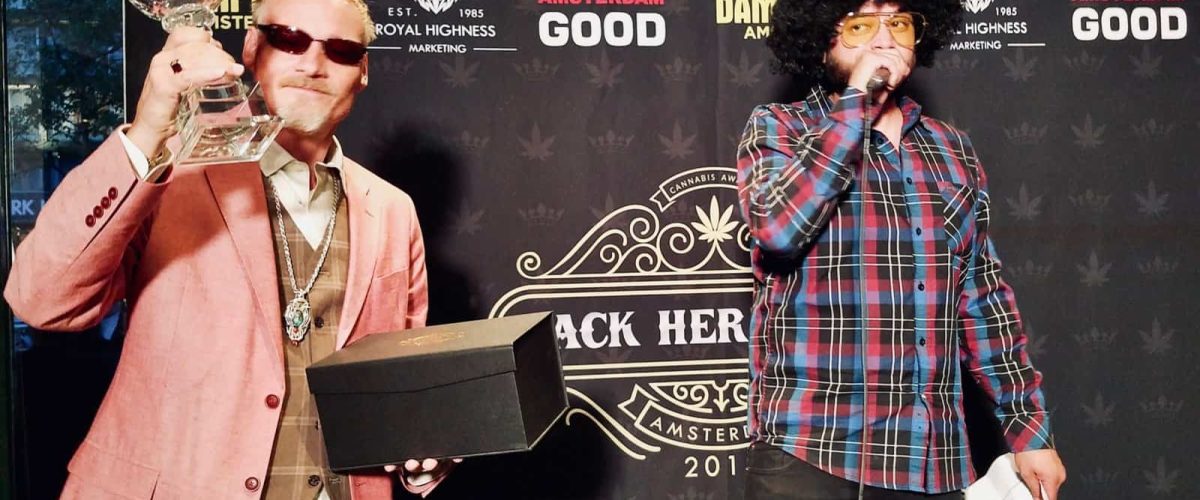 Elegant man holding a cannabis award trophy at an Amsterdam cannabis event.