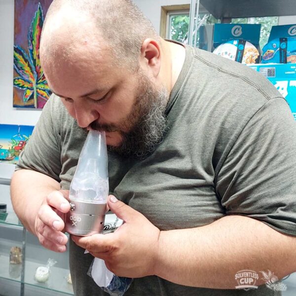 Man vapes rosin out of DabX erig in dispensary setting